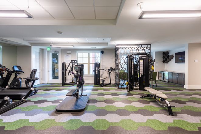 A modern gym with various exercise equipment and a spacious layout.