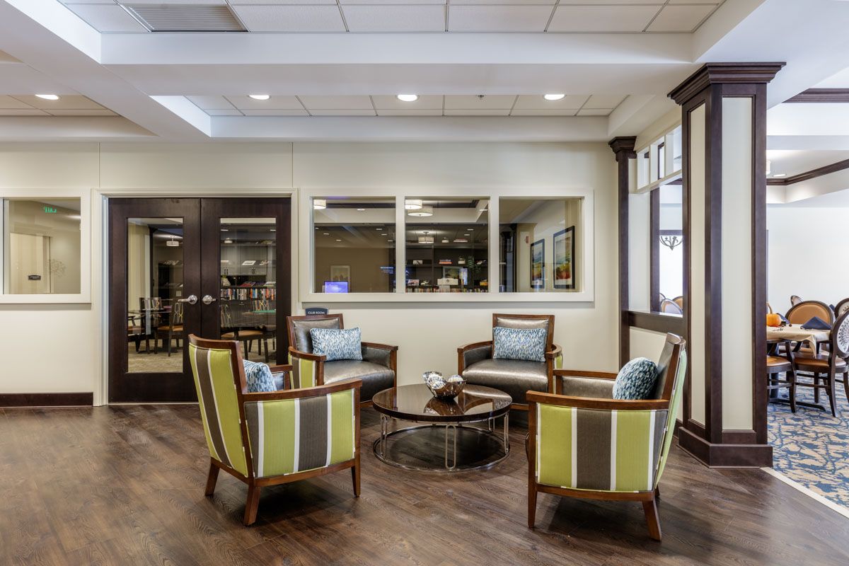 A modern lobby with a seating area featuring four chairs around a small table.