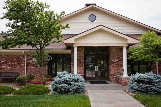 A welcoming entrance of a residential building surrounded by well-maintained landscaping.