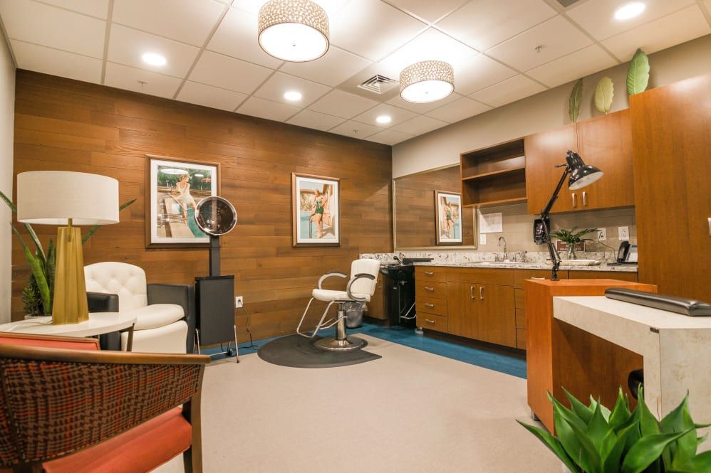 A modern hair salon interior with stylish chairs and wood paneling.