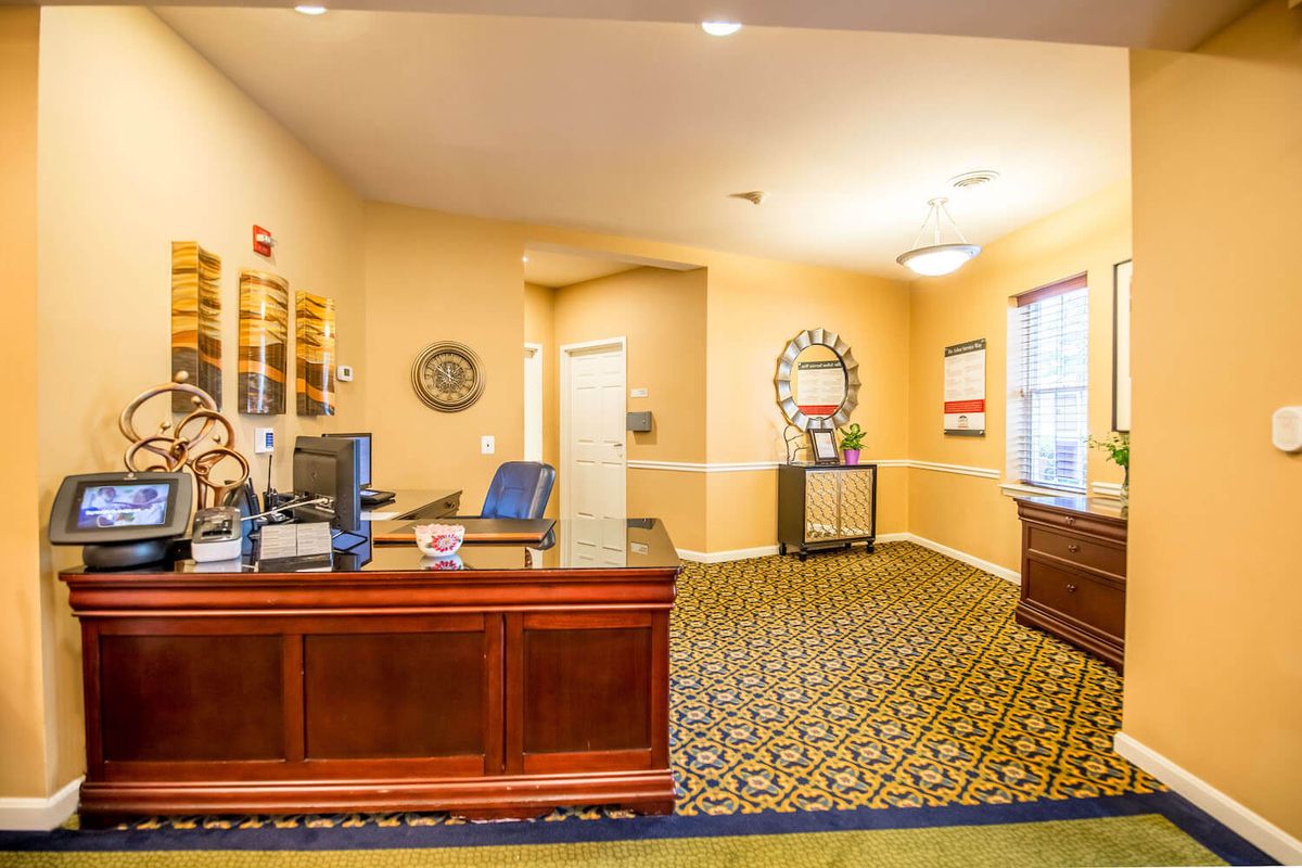 A well-lit office reception area with a wooden desk and decorative elements.