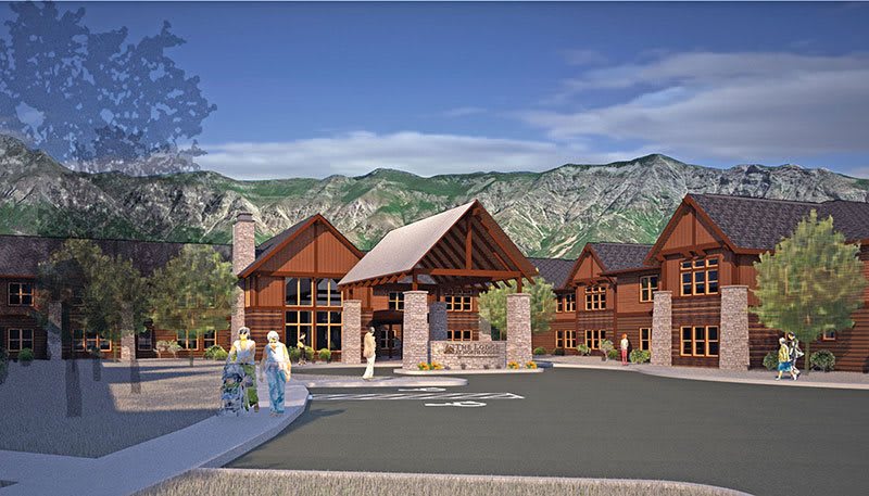 A scenic view of a resort-style building set against a backdrop of mountains.