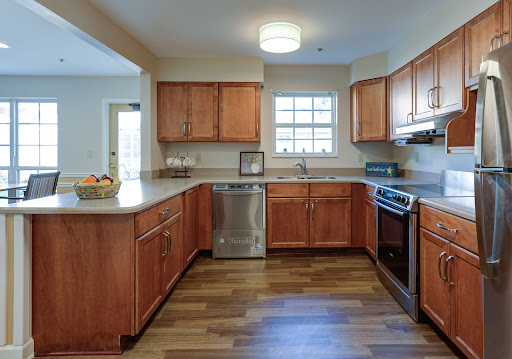 A modern kitchen featuring wooden cabinets, stainless steel appliances, and natural lighting.