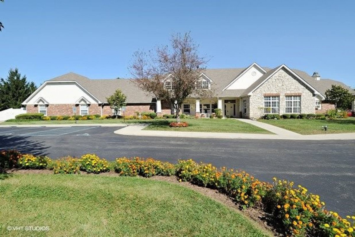 A suburban house with a well-maintained front yard and driveway on a sunny day.