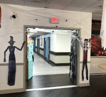 A creatively decorated entrance to a hallway, featuring spooky figures on either side.