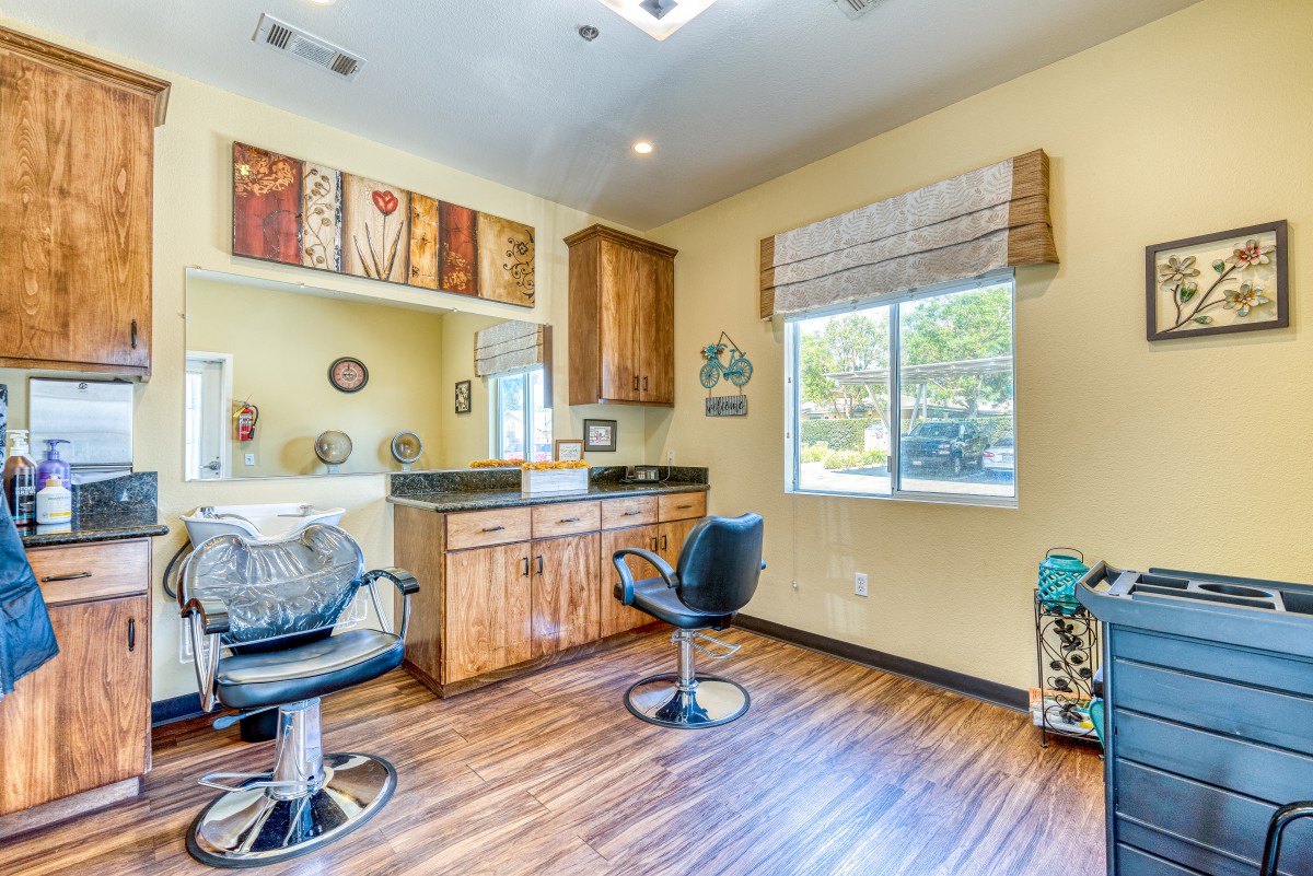 A modern hair salon interior with wooden flooring and stylish chairs.