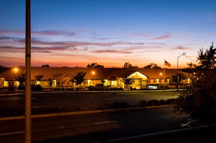 A serene view of a building at sunset, with a colorful sky in the background.
