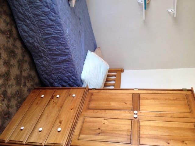 A cozy bedroom with a wooden bed and wardrobe.