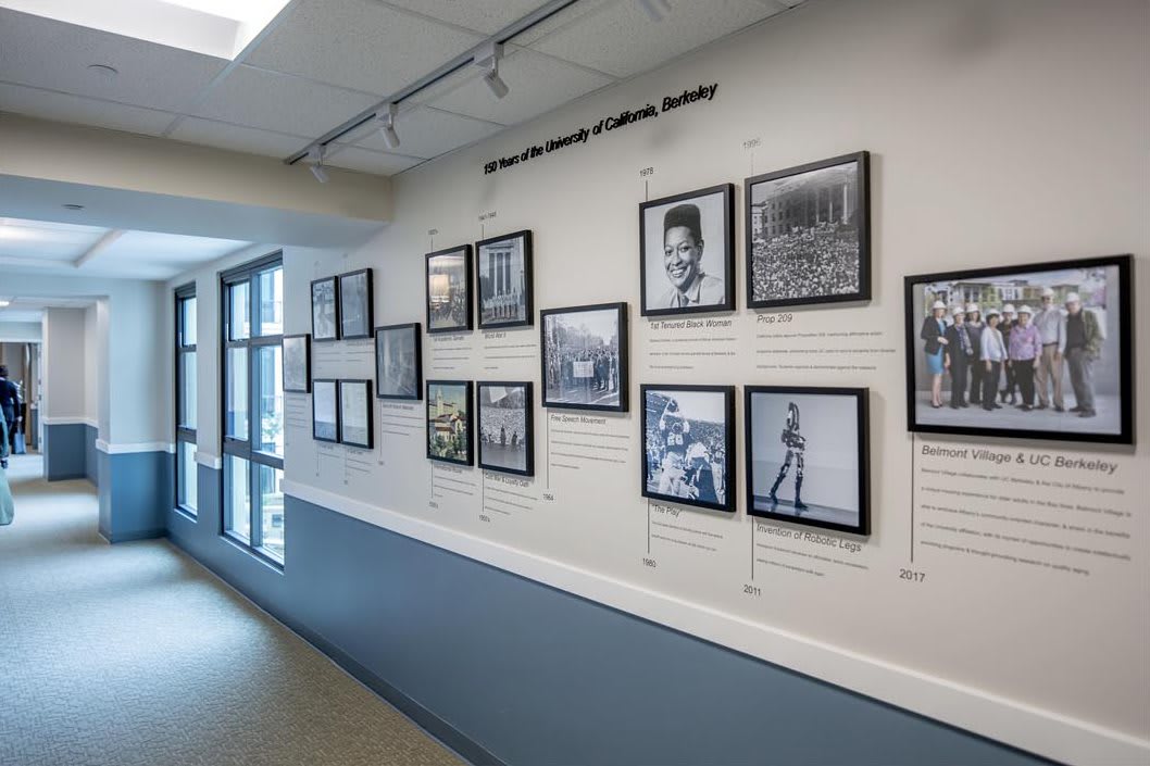 A modern art gallery hallway displaying a collection of black and white historical photographs on the wall.
