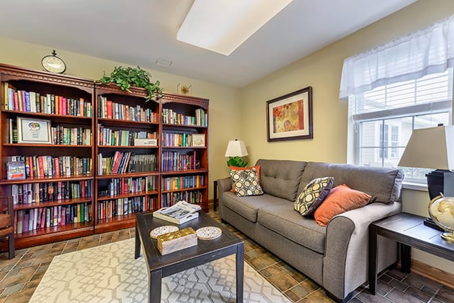 A cozy living room with a plush sofa, a well-stocked bookshelf, and stylish decor.