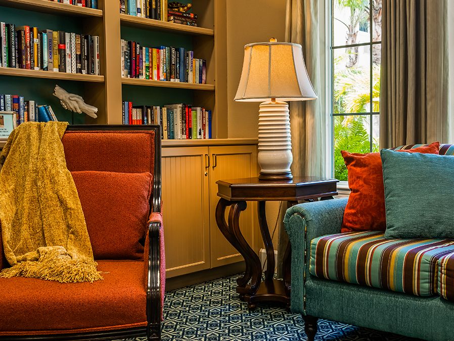 Cozy living room with a bookshelf, elegant lamp, and comfortable seating.