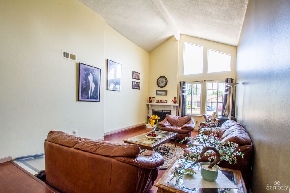 A spacious living room with comfortable sofas, a coffee table, and large windows letting in natural light.