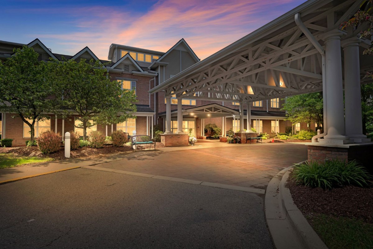 A cozy hotel entrance illuminated during the evening, showcasing its charming architecture and inviting ambiance.