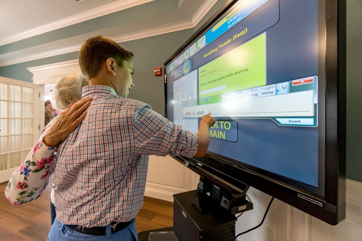 A child interacts with a large touchscreen for educational purposes.