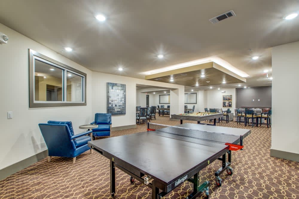 A modern game room featuring a ping pong table and comfortable seating.