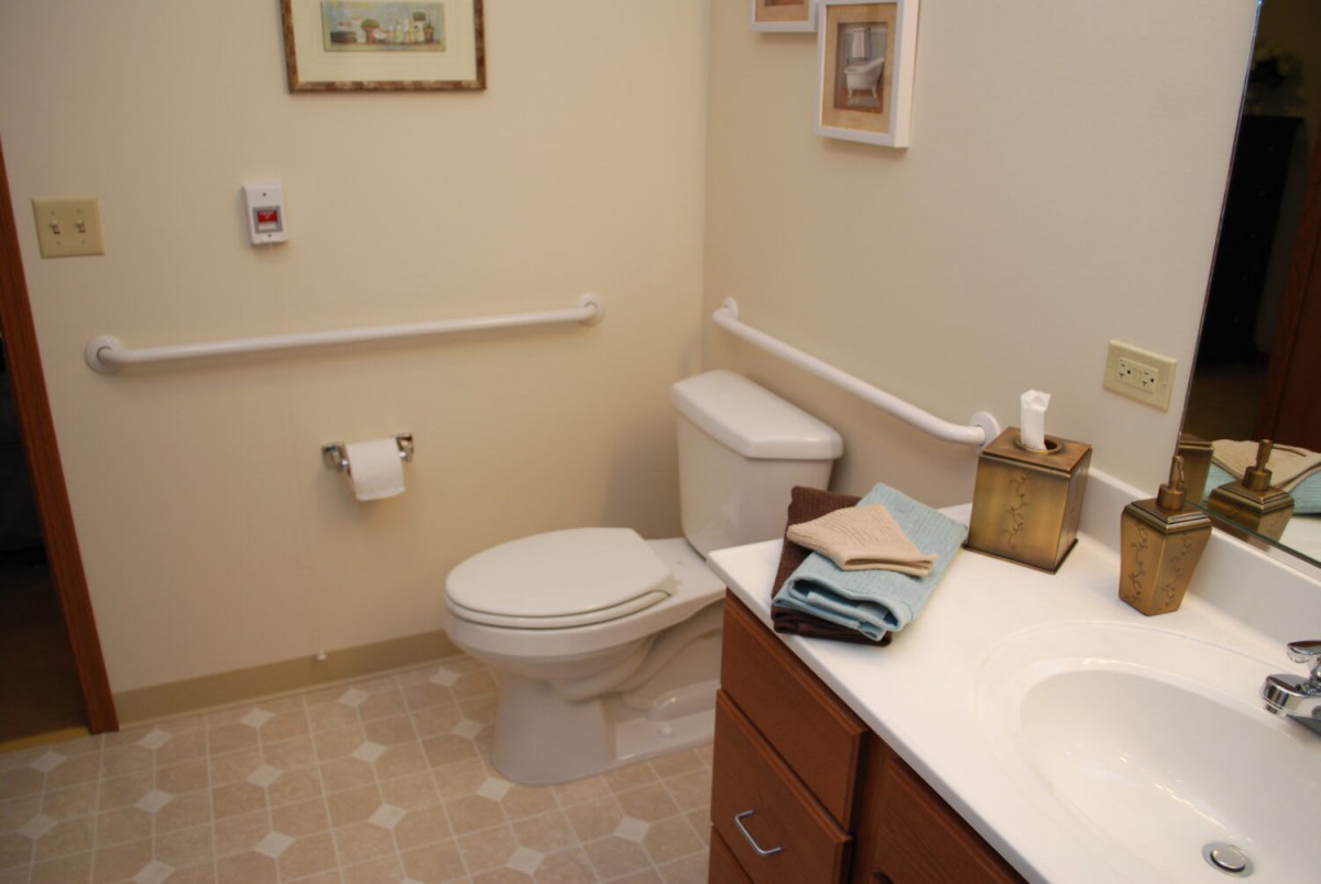 A clean bathroom featuring a toilet, sink, and neatly folded towels.