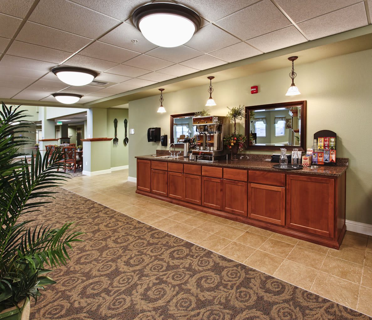 A well-lit hotel lobby with a coffee station and elegant interior design.