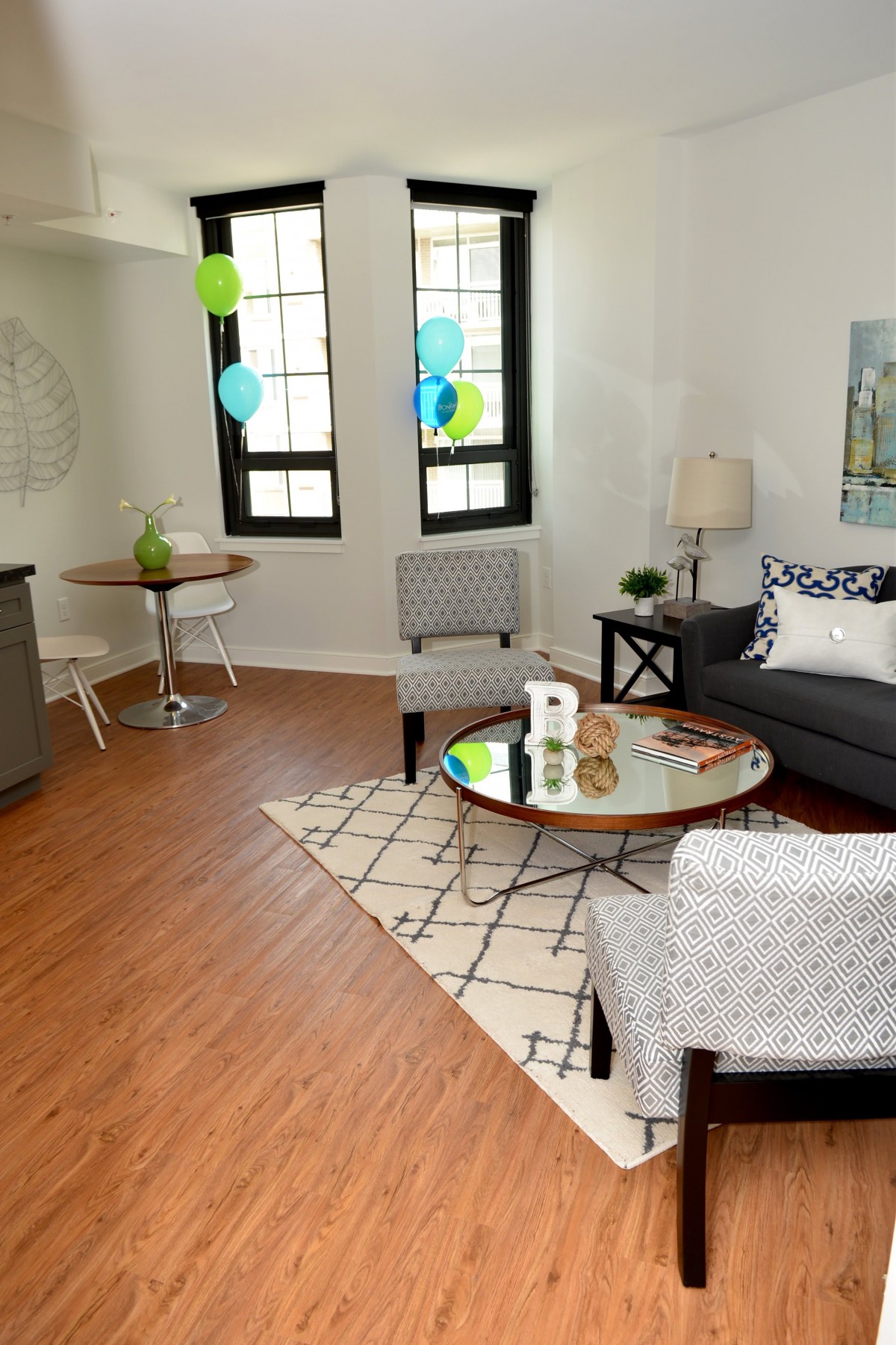 A modern living room with stylish furniture and decor, featuring large windows and hardwood flooring.