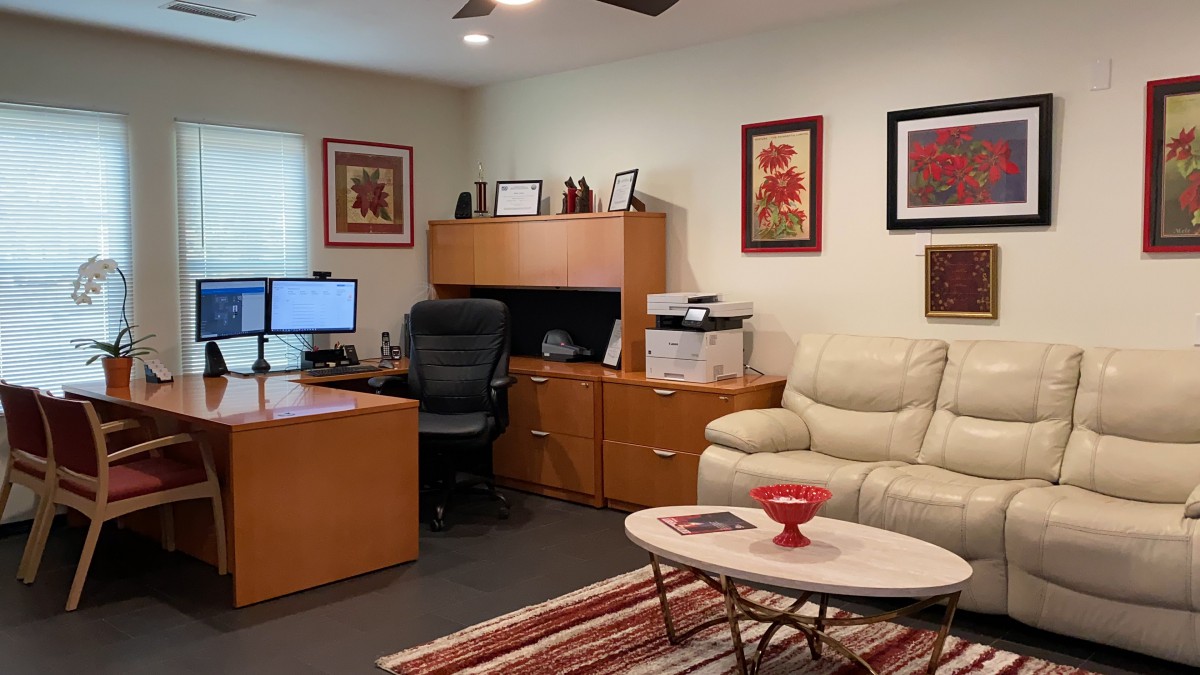 A modern home office with a desk, computer, comfortable chair, and stylish decorations.