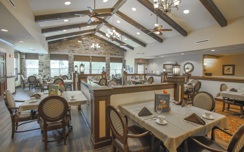 A spacious and elegantly decorated restaurant interior with high ceilings and classic furnishings.
