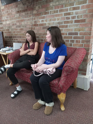 Two individuals sitting on a couch in a casual setting.