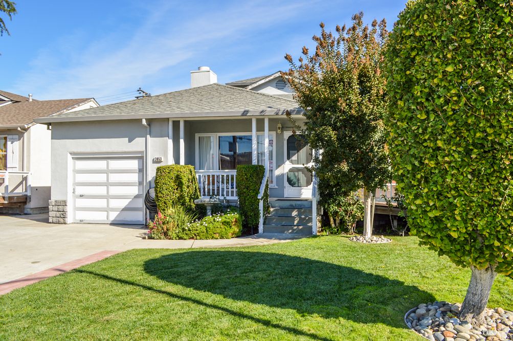 A suburban house with a neatly maintained front yard on a sunny day.