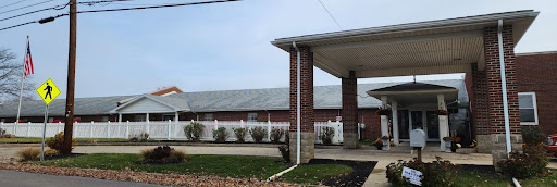 A brick building with a covered entrance and landscaped area.