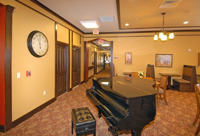 A cozy hallway interior featuring a grand piano and seating area.