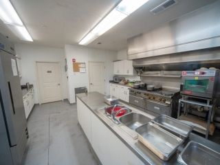 A spacious and clean commercial kitchen equipped with stainless steel appliances and cooking equipment.