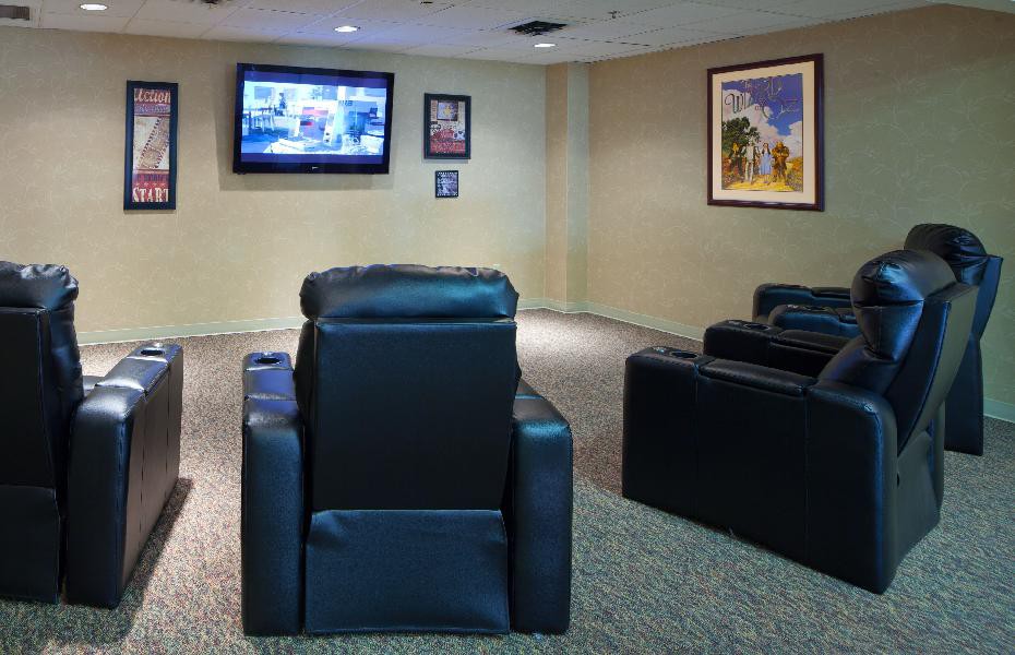 A cozy home theater setup with leather recliners facing a wall-mounted television.