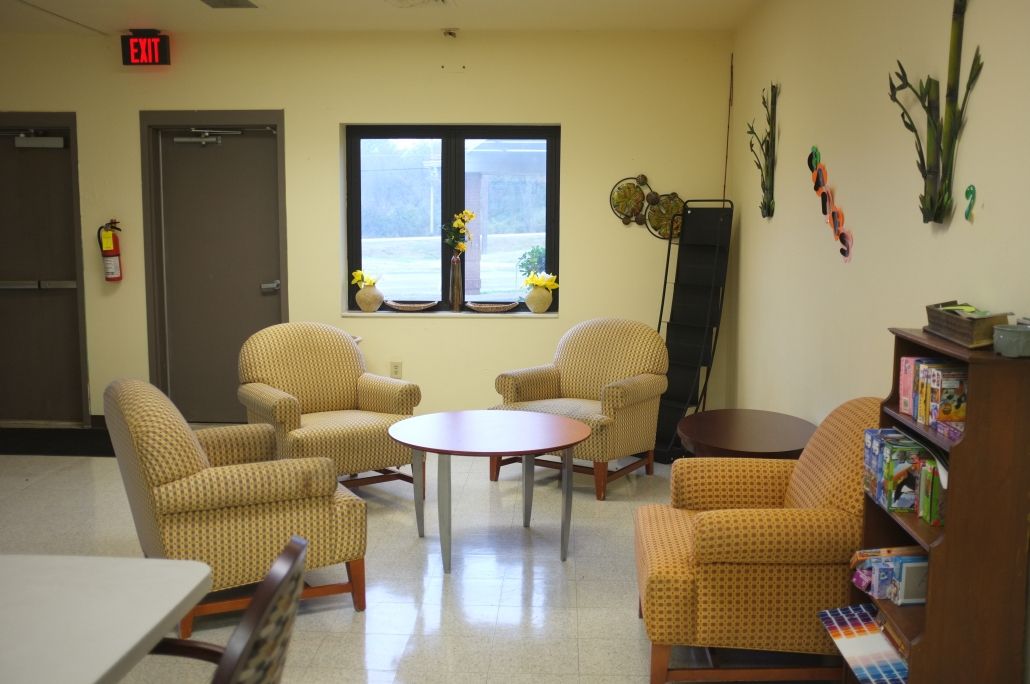 A cozy waiting room with comfortable chairs and a central table.