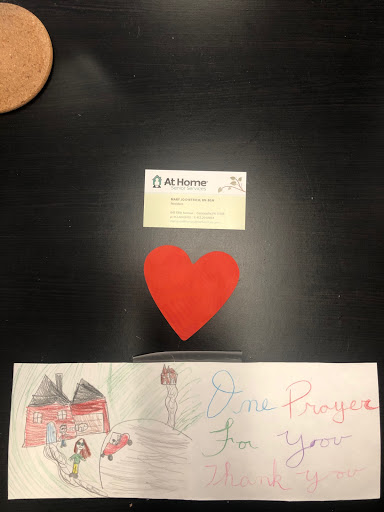 A handmade red heart surrounded by a colorful drawing and a card, symbolizing love and creativity.