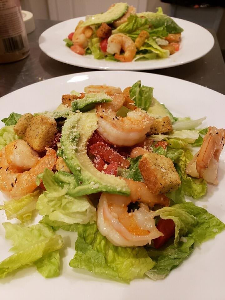A fresh shrimp salad with avocado, croutons, and lettuce.