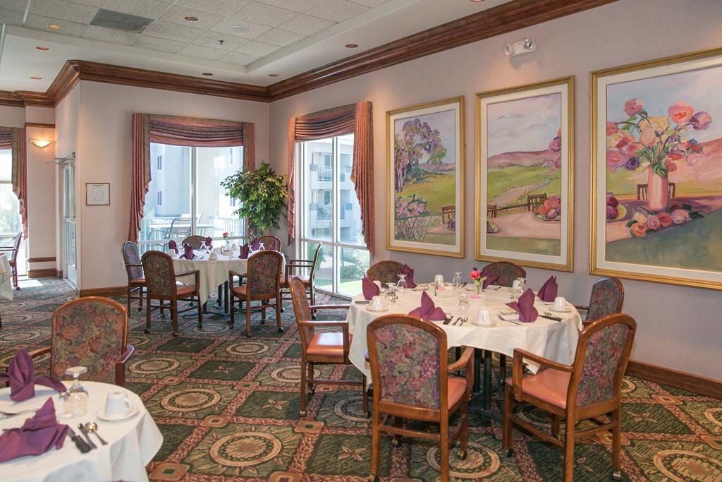 A elegantly decorated restaurant dining room with set tables and artwork on the walls.