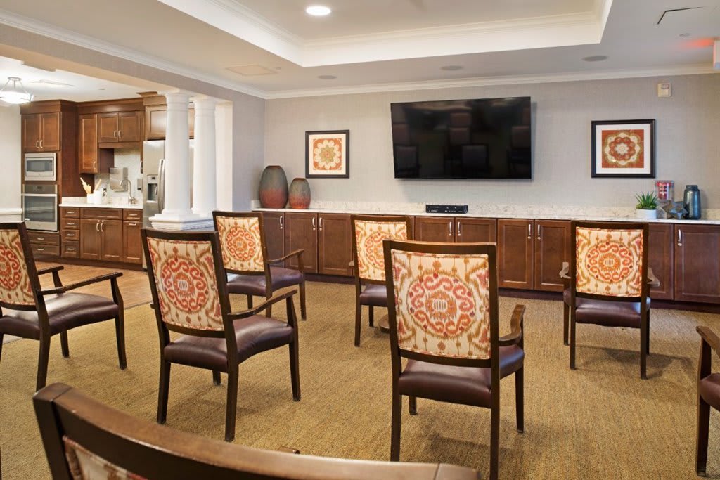 A well-organized meeting space with arranged chairs facing a large television.
