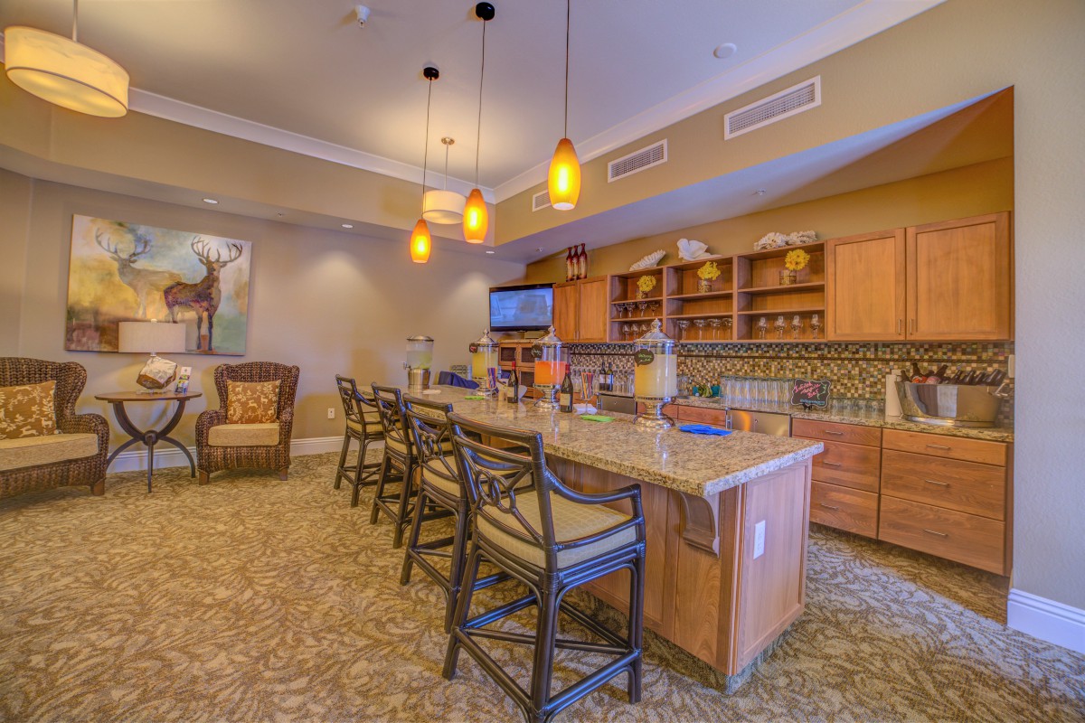 A modern kitchen interior with a large countertop and bar stools.