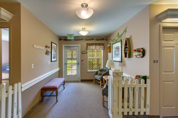 A warmly decorated hallway with a bench and artwork lining the walls.