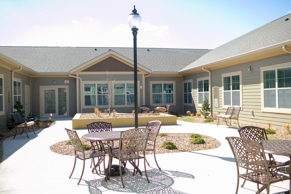 An outdoor patio area with tables and chairs in a courtyard setting.