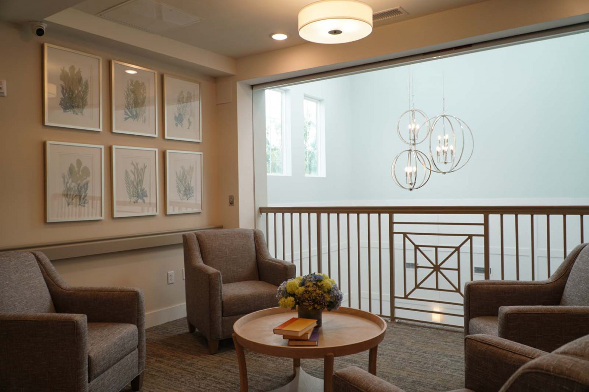 A cozy waiting area with comfortable chairs, a central coffee table, and elegant wall decor.