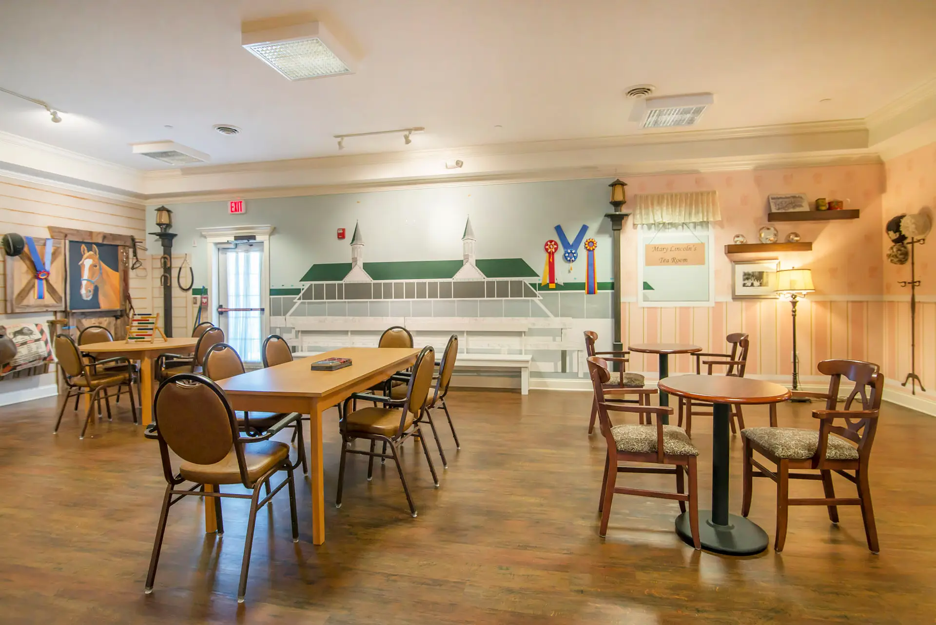 A cozy dining area with tables and chairs, featuring a wall mural.