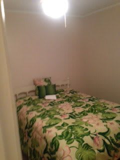 A cozy bedroom with floral bedding and pillows.