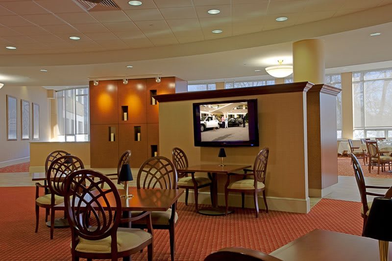 A modern hotel lobby with a seating area and television.