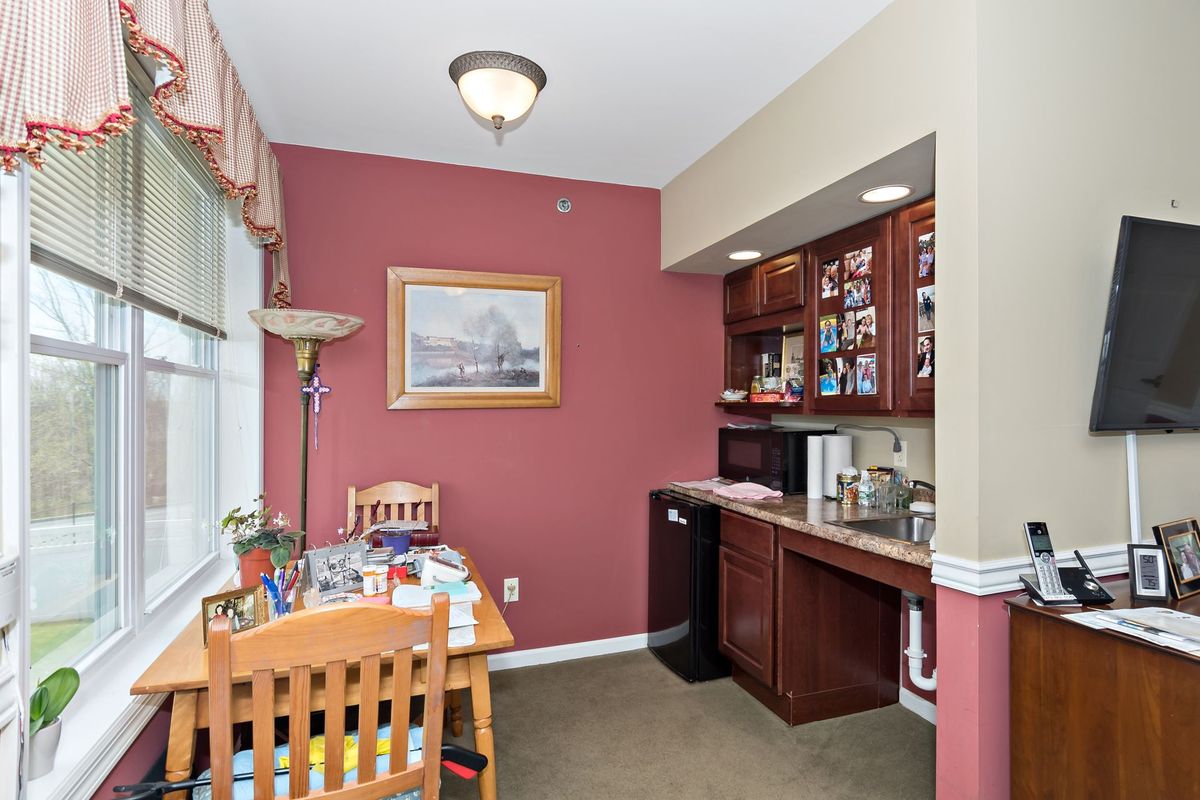 A cozy dining and kitchenette area with wooden furniture and warm-colored walls.