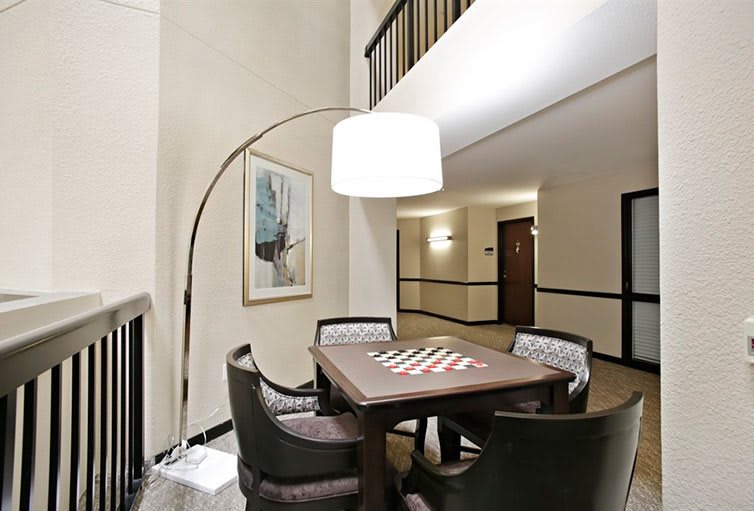 A modern seating area with a table, chairs, and an overhead lamp.