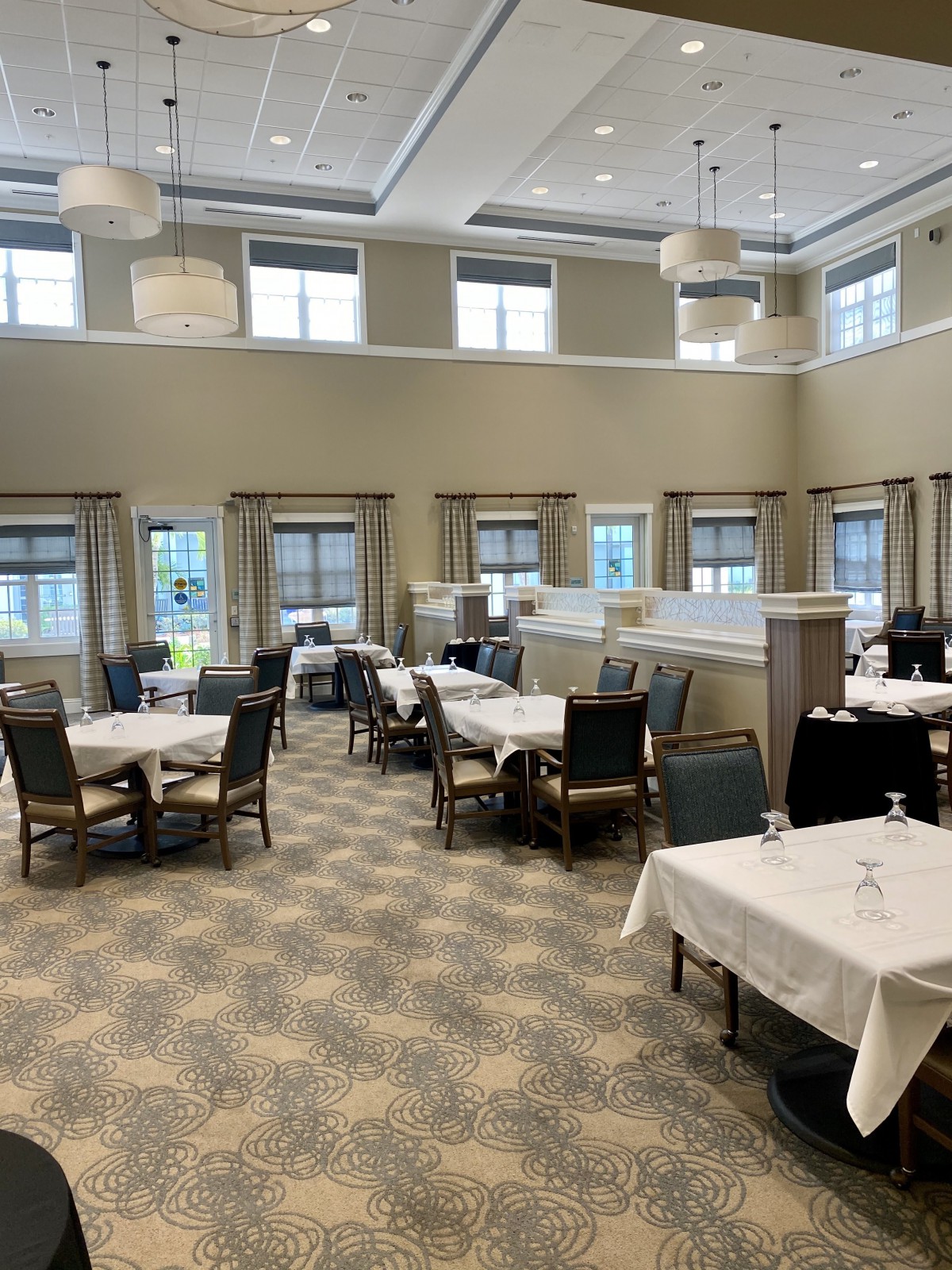 A spacious and elegantly designed restaurant dining area with neatly arranged tables and chairs.