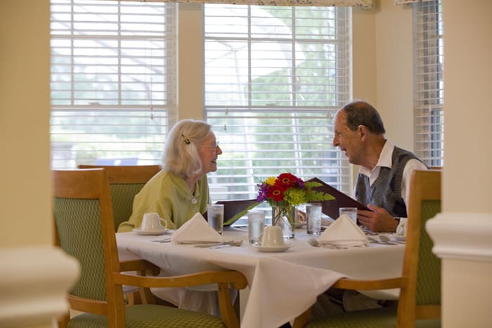 An elderly couple enjoying a meal together at a restaurant.
