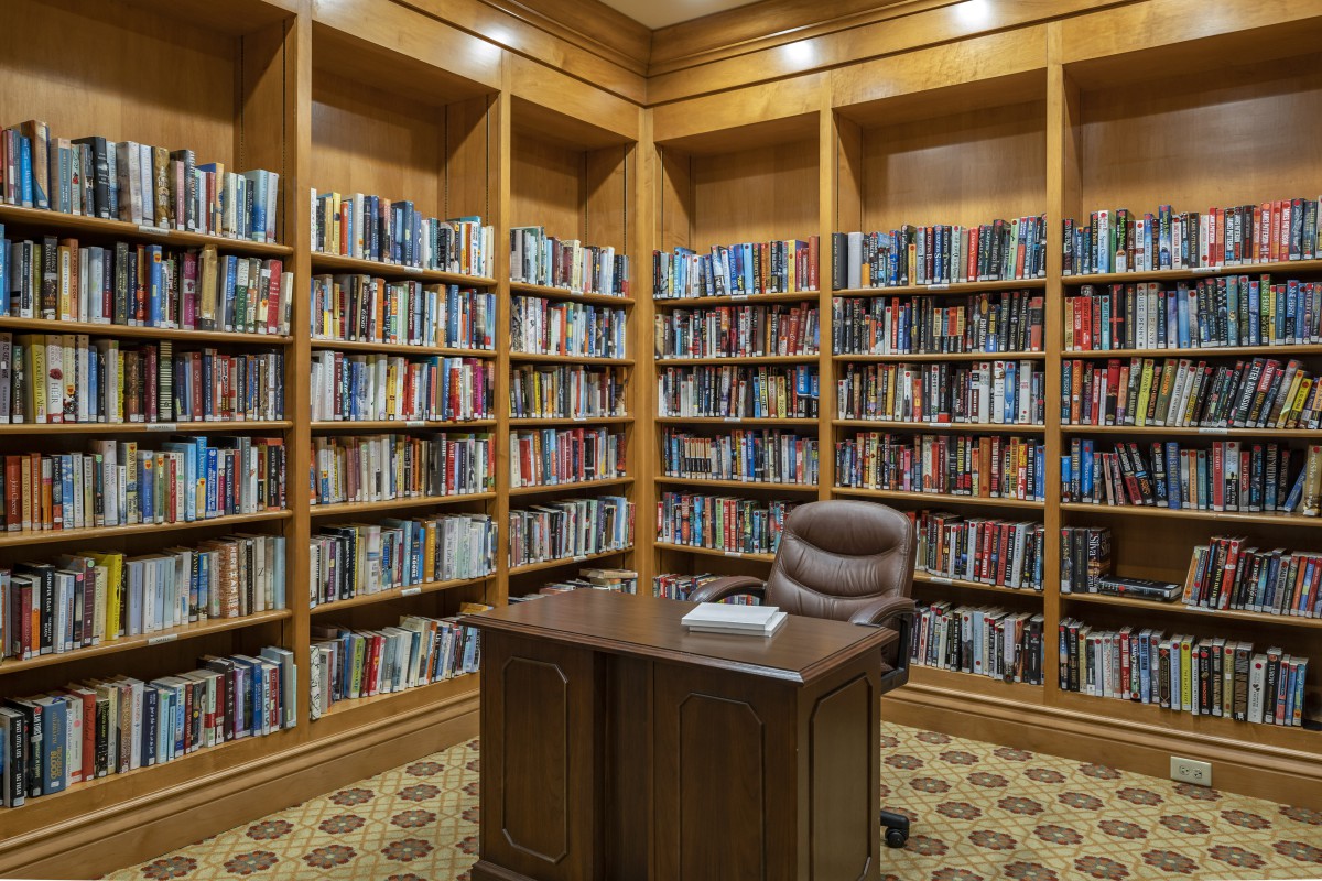 A cozy library corner with wooden bookshelves and a desk.