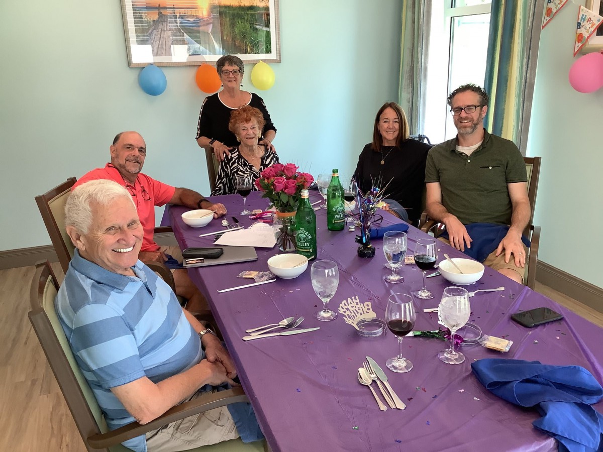A group of people gathered around a table set for dinner, enjoying a celebration.