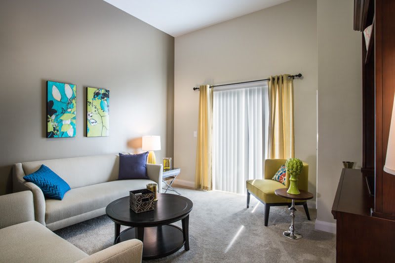 A modern living room with stylish decor, featuring a comfortable sofa, coffee table, and vibrant artwork.