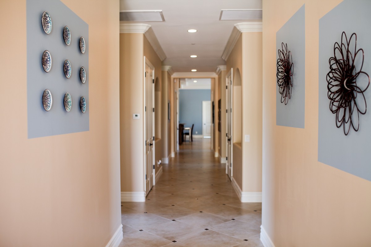 A well-lit hallway with artistic wall decor and multiple doors.